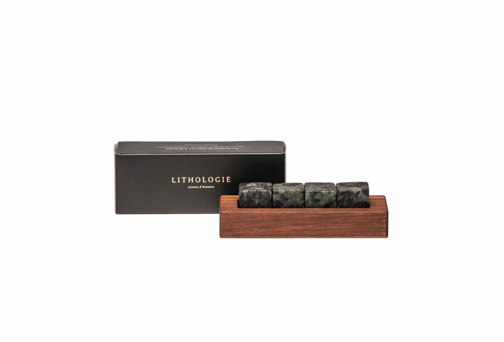 4 black and white whisky stones set in a walnut display and box cover on the side.